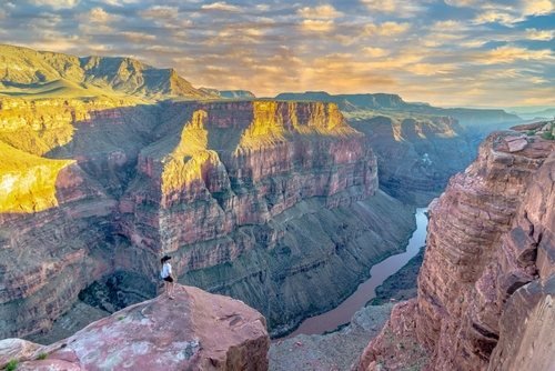 Abendlicht auf den Felswänden des Grand Canyon, tief unten der Colorado River