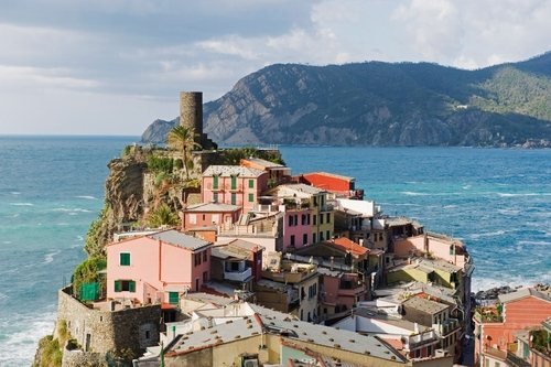 Bunte Häuser von Vernazza auf einem Felsen am Meer, mit rundem Turm